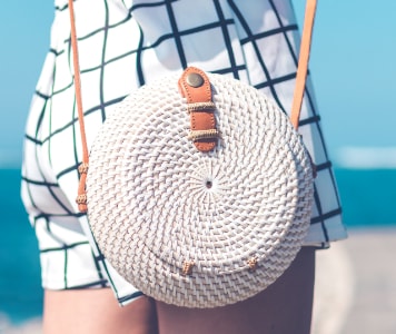 Trendi fonott kerek női táska a strandon