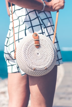 Trendi fonott kerek női táska a strandon