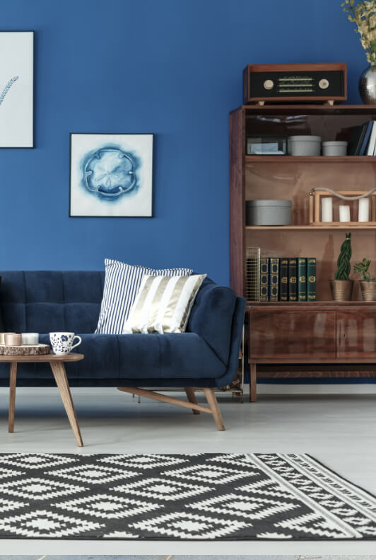 Modern bútorok kékre festett fal előtt