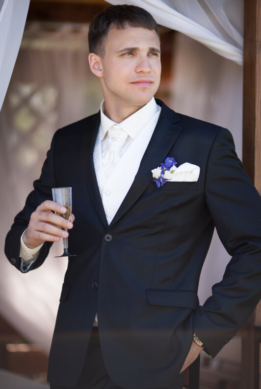 Férfi vendég pezsgővel esküvői szmokingban