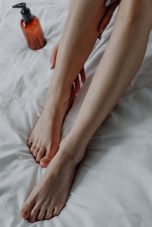 Ápolt női lábak és mellettük egy tubus lábápoló krém