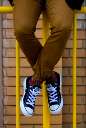 Chino nadrágot viselő férfi lábai Converse Chucks-ban