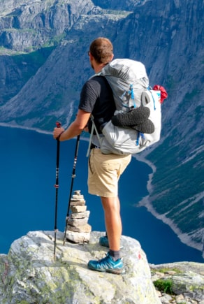 Férfi rövidnadrágban, hátizsákkal egy hegy tetején
