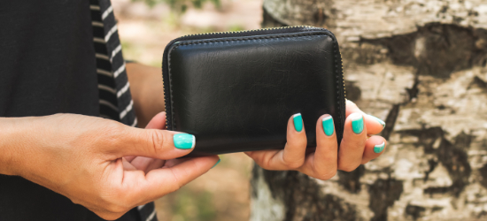 Nő kezében fekete pénztárca